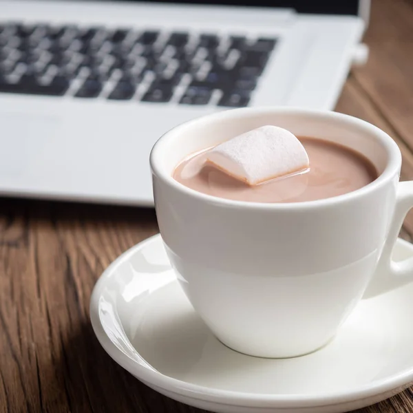 Hatmi ve ahşap arka plan üstünde laptop ile kakao fincan. Kare