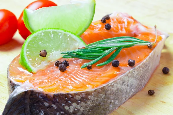 Kireç, baharatlar ve sebzeler bir ahşap zemin üzerine somon steak.