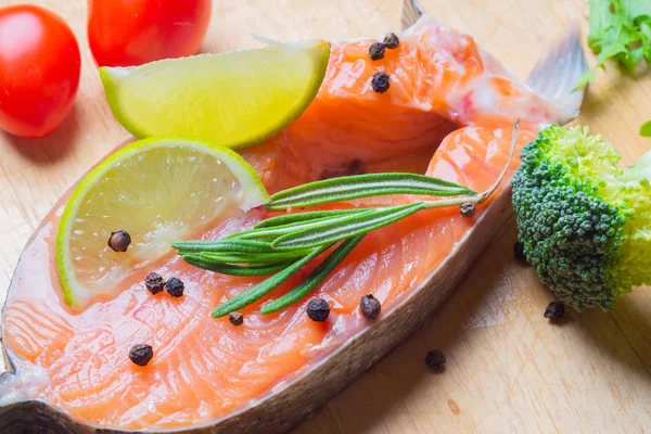 Kireç, baharatlar ve sebzeler bir ahşap zemin üzerine somon steak.