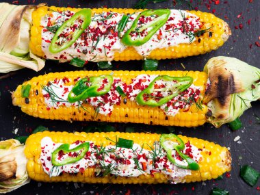 Krema sos, baharat, jalapeno siyah taş kutunun üzerindeki ile ızgara Mısır.