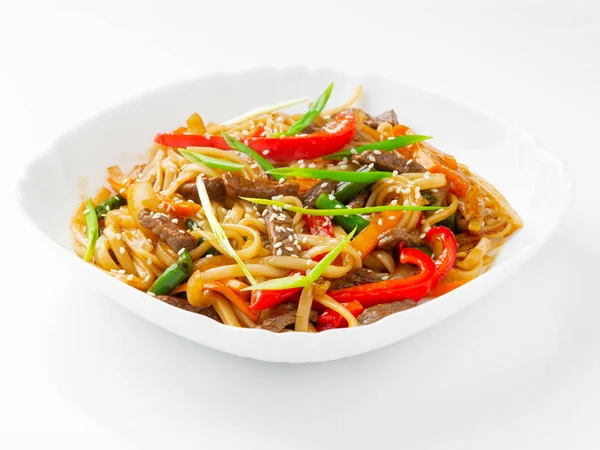 Beyaz tabakta biftek ve teriyaki soslu Udon eriştesi..