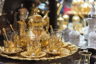 Traditional tea sets at Grand Bazaar in Istanbul, Turkey. Golden color teapot and Turkish tea cups clipart