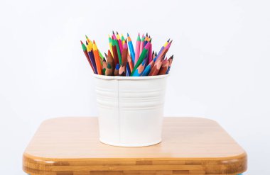 Beyaz arka plan üzerinde beyaz metalik kalem kılıfı renkli kalemler.