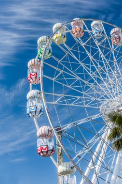 Eğlence parkında renkli dönme dolap. Mavi arka planlı dönme dolap. Lunapark. 