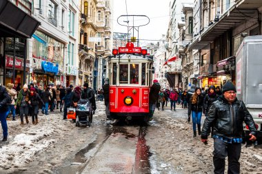 İSTANBUL, TURKEY - 31 Aralık 2015: Taksim, Beyoğlu 'nda karlı bir gün. Istiklal Caddesi 'nde nostaljik tramvay. Taksim İstiklal Caddesi İstanbul, Türkiye 'de popüler bir yer.
