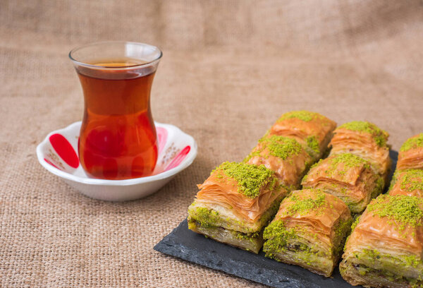 Турецкая сладкая пахлава на тарелке с турецким чаем
.