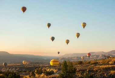 CAPPADOCIA, GOREME, TURKEY - 4 Eylül 2016: Kapadokya, Türkiye 'de kayaların üzerinde uçan sıcak hava balonu.