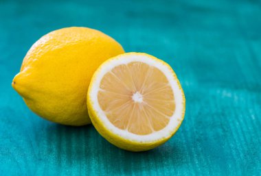 Yeşil arka planda taze kesilmiş limonlar.