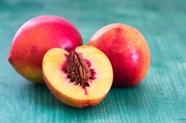 Şeftali. Yeşil arka planda dilimlenmiş meyve