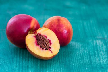 Şeftali. Yeşil arka planda dilimlenmiş meyve