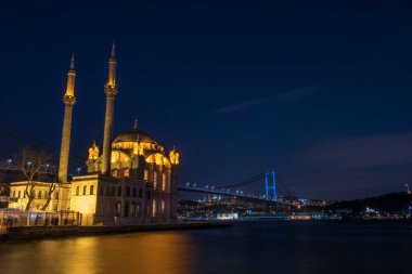 Ortaköy Camii ve Boğaziçi Köprüsü (15 Temmuz Şehitler Köprüsü) gece manzarası. İstanbul, Türkiye.