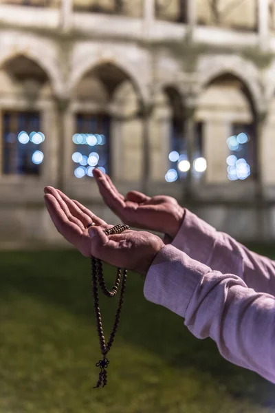 Praying Muslim Man with prayer-beads (Tesbih). Praying Muslim Man with mosque background in Ramadan Kareem. Istanbul, Turkey.