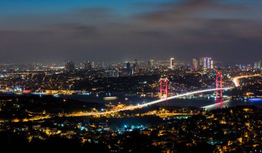 İstanbul Boğazı Köprüsü, gece. 15 Temmuz Şehitler Köprüsü. Camlica Hill 'den gece görüşü. İstanbul, Türkiye.