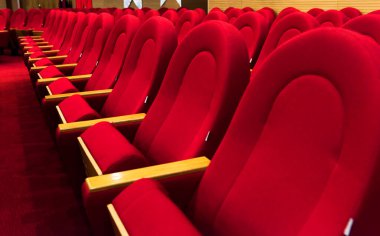 Boş kırmızı sandalyeler. Yakın çekim. Sinema, tiyatro, konser salonu.