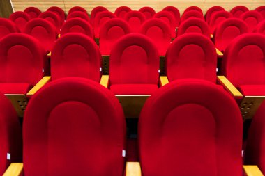 Boş kırmızı sandalyeler. Yakın çekim. Sinema, tiyatro, konser salonu.