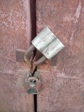  two old padlocks on rusty iron doors