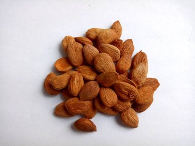 Bir grup kayısı tohumu beyaz bir arkaplanı kaplar.