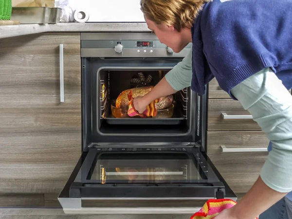 从焙烧炉烤箱取出烤鹅的妇女 — 图库照片