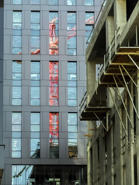 Red Jib Crane Reflecting Highrise Building Glass Facade — Stock Photo, Image