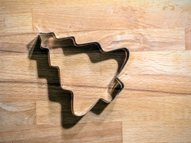 Noel ağacı şeklindeki metal çerez kesici ahşap tahta üzerinde