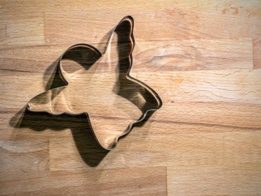 Melek şeklindeki metal çerez kesici ahşap tahta üzerinde