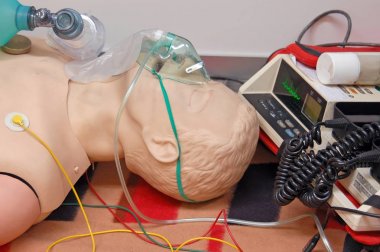Elektrokardiyograf ünitesine bağlı solunum maskesi ve sensörleri ile ilk yardım eğitimi mankeni 