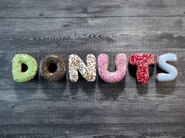 Letter Donuts mit unterschiedlichem Sahnehäubchen — Stockfoto