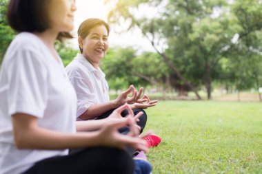 Yaşlı asyalı kadın sabah parkta oturan yoga pratik,Mutlu ve gülümseyen,Pozitif düşünme, Sağlıklı ve yaşam tarzı kavramı