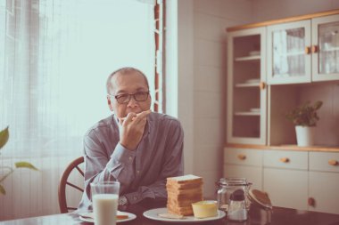 Kahvaltı için Asya yaşlı erkek eathing ekmek sağlıklı gıda, Emeklilik üst düzey yaşam tarzı yaşam konsepti