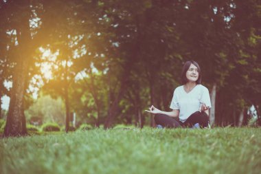 Güzel Asyalı kadınlar akşam parkta yoga, Mutlu ve gülümseyen, Pozitif düşünme, Sağlıklı ve yaşam tarzı kavramı