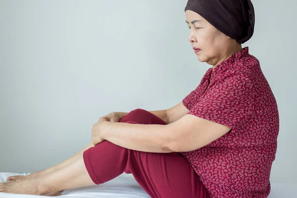 Senior asian woman with disease cancer sitting in her bedroom,Elderly female feeling depressed and upset,Chemotherapy concept