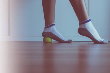 Yatak odasında ayağına tenis topuyla kadın masajı, ayak tabanı masajı, ayak bileği iltihabı.