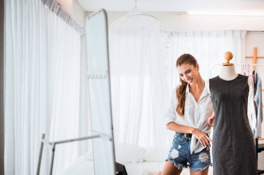 Giyim mağazasında duran ve elbise seçiminde genç güzel kadınlar,Mutlu ve gülümseyen,Moda ve yaşam tarzı konsepti