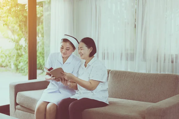 Krankenschwester Kümmert Sich Das Vorlesen Eines Buches Für Ihre Patientin — Stockfoto