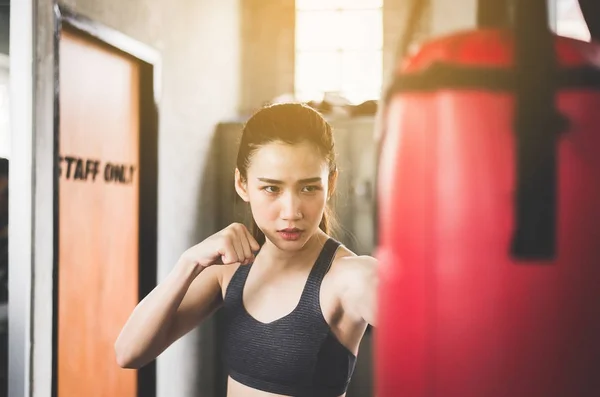 Woman boxer punching at a boxing gym,Women boxer training on punching bag