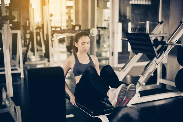 Asian fit woman doing situp or crunches in gym,Female exercise muscular her stomach