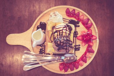 Bal tost çikolata ve vanilyalı dondurma krem şanti ile Tepesi, badem dilimi, çilek, şurup, Üst görünüm ve vintage tonda