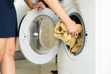 Evde çamaşır yıkama yapan çamaşır makinesine kirli kıyafetler giyen el kadın