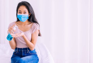 Temizlik koronavirüsü koruması için pompa şişesine dezenfektan jeli kullanan Asyalı kadın.
