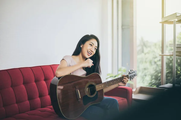 Mulher Bonita Cantando Tocando Guitarra Enquanto Sentada Sofá Sala Estar — Fotografia de Stock