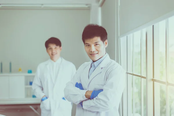 腕を組んでポーズをとるアジアの男性科学者が病院で働く プロの医療チームワーク — ストック写真