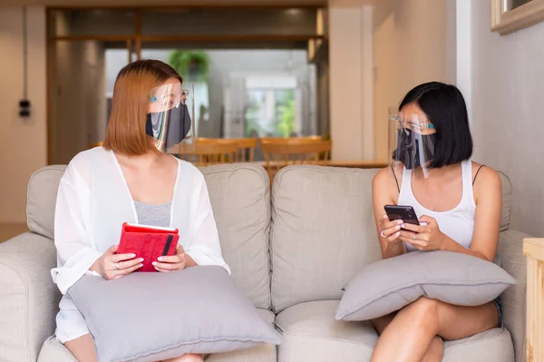 Asiatische Frauen Mit Gesichtsschutz Und Schutzmasken Die Auf Dem Sofa — Stockfoto