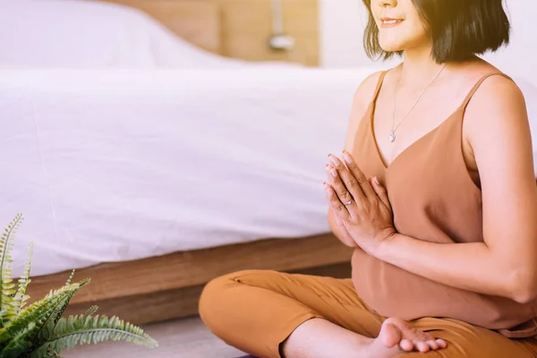 快乐的亚洲女人坐在卧室练习瑜伽冥想 早上醒来后锻炼身体 健康和生活方式的概念 — 图库照片
