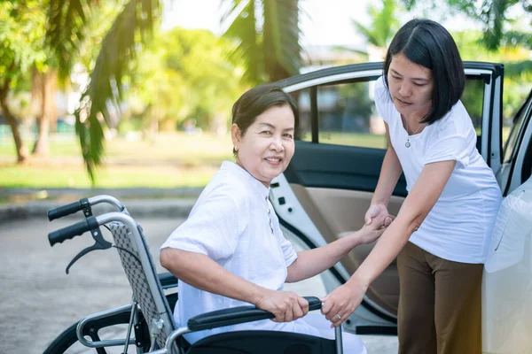 Gondozó Segít Idősebb Fogyatékos Ázsiai Tolószék Beszállni Autóba — Stock Fotó