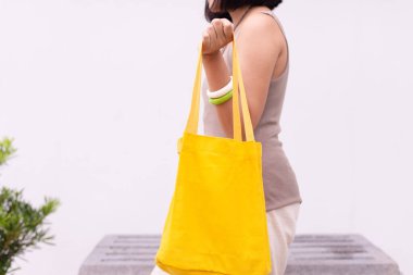 Beyaz arka planda tekrar kullanılabilir eko çanta tutan kadın.