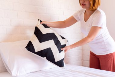 Bir yatak yap, sabah kalktıktan sonra yatağını toplayan kadın elleri.