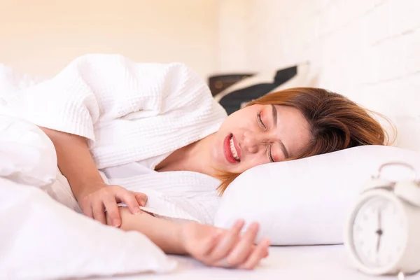 Yatakta uyuyan ve dişlerini gıcırdatan Asyalı kadın, kadın bruxism