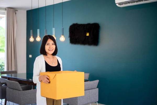 新しい家で大きな段ボール箱を持って幸せなアジアの女性 移動日 — ストック写真