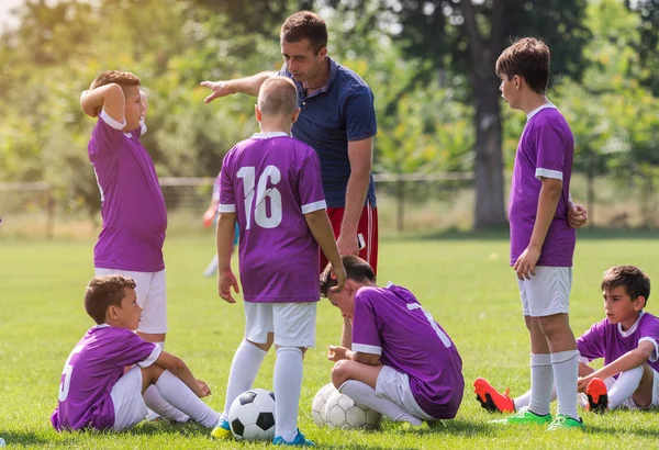 コーチがサッカーの試合で若いサッカー選手への助言します — ストック写真