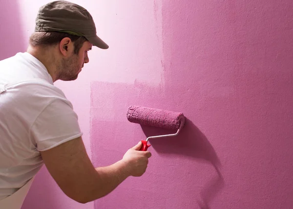Jovem Está Pintando Parede Com Rolo Pintura — Fotografia de Stock